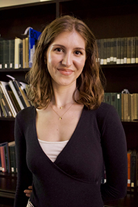 photo of Lydia Mayhood posing in front of a bookshelf