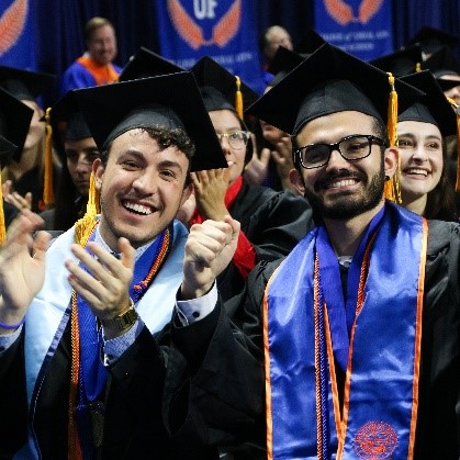 a group of smiling men wearing graduation caps and gowns